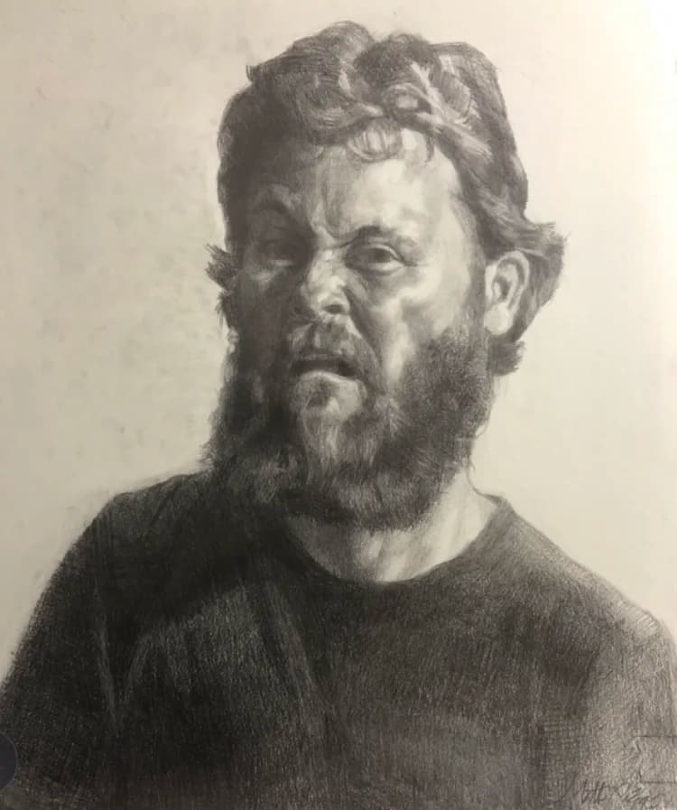 Charcoal portrait of a bearded man looking out of the picture, drawn on white paper.