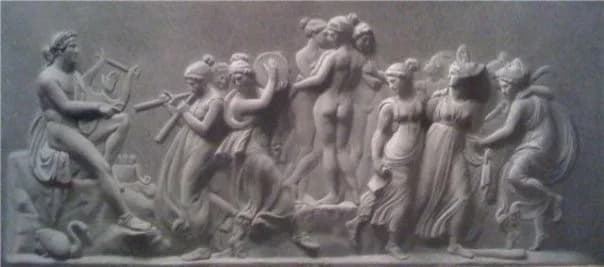 Low-relief panel of a classical procession — seated figures, pipes and dancers in a frieze.