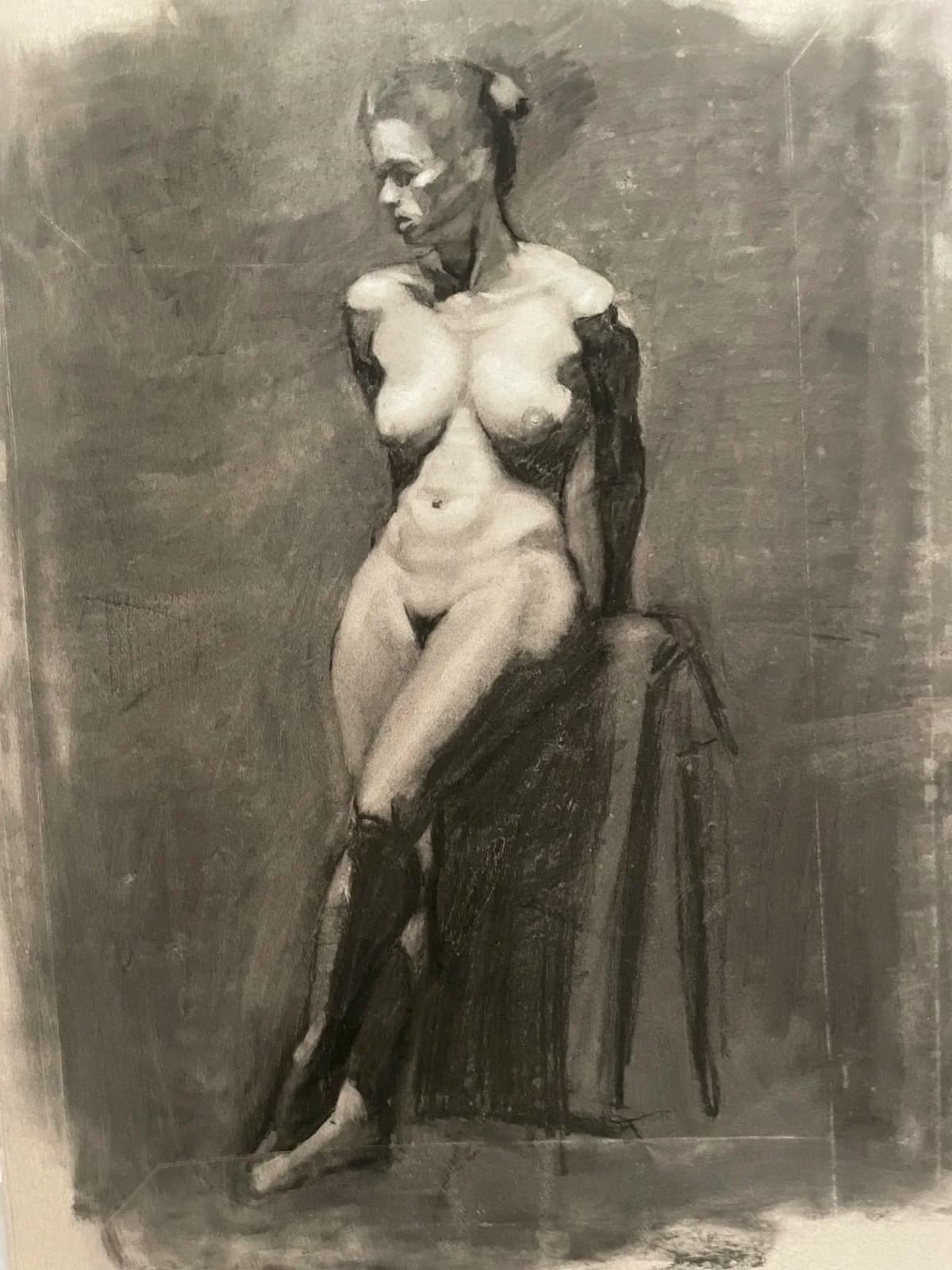 Charcoal study of a seated female figure, the drapery behind her rubbed back into the ground.