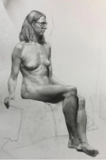 Pencil study of a seated figure, the chair and the floor line drawn in lightly around her.